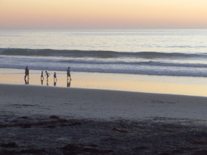 Family doing foot lift and pushes on the beach in Caifornia